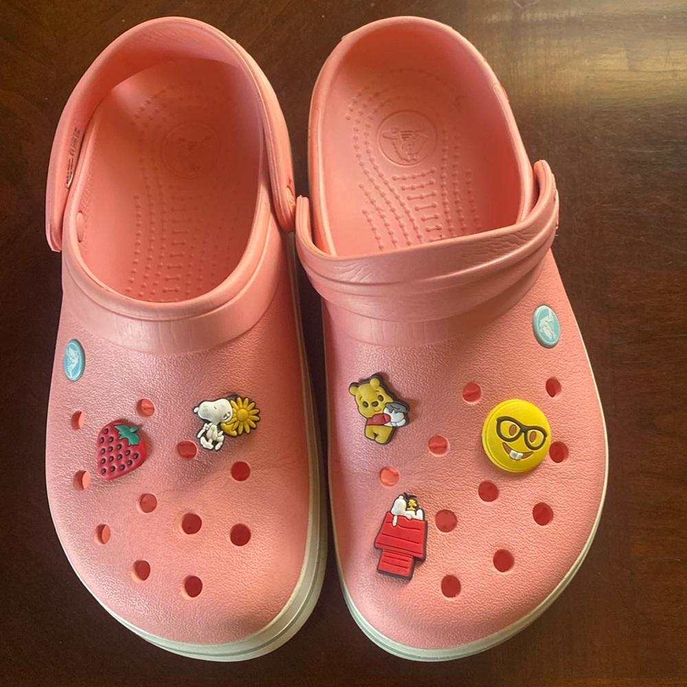 🦊 Pink/peach crocs with charms.